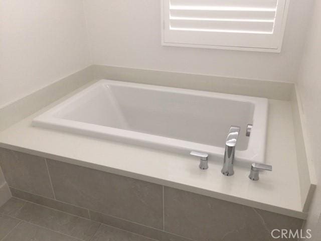 bathroom with tile patterned floors and a bathing tub