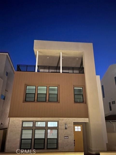 view of front of property featuring a balcony