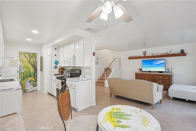 kitchen featuring white cabinetry, ceiling fan, fridge, electric range, and light tile patterned floors