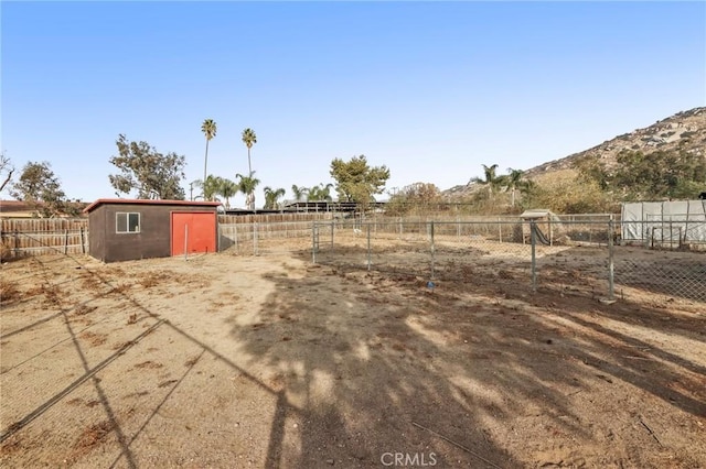 view of yard featuring a rural view, a mountain view, and a storage unit