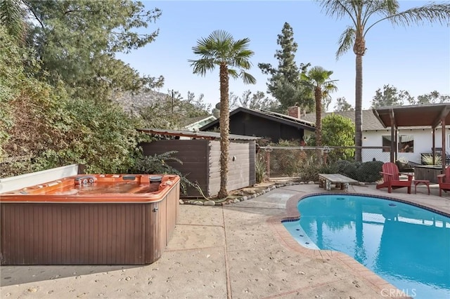 view of swimming pool featuring a patio area and a hot tub