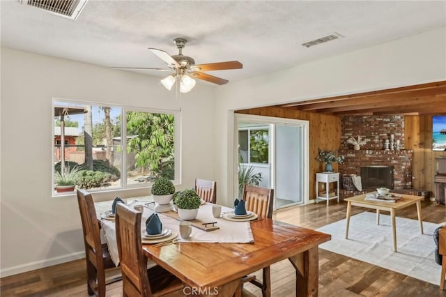 dining room with dark wood-type flooring, a healthy amount of sunlight, and ceiling fan