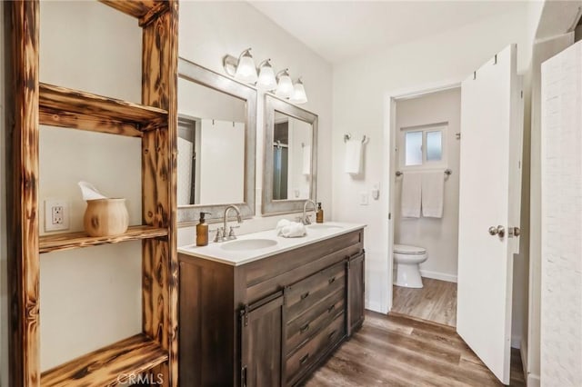 bathroom featuring wood-type flooring, toilet, and vanity