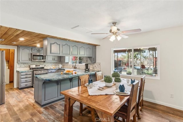 kitchen with ceiling fan, gray cabinetry, stainless steel appliances, and tasteful backsplash