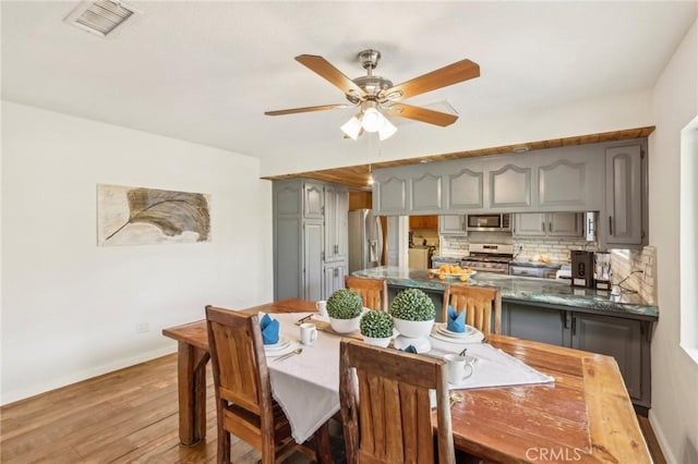 dining room with ceiling fan and light hardwood / wood-style floors