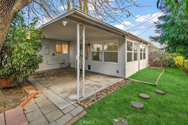 back of house featuring a lawn and a patio area