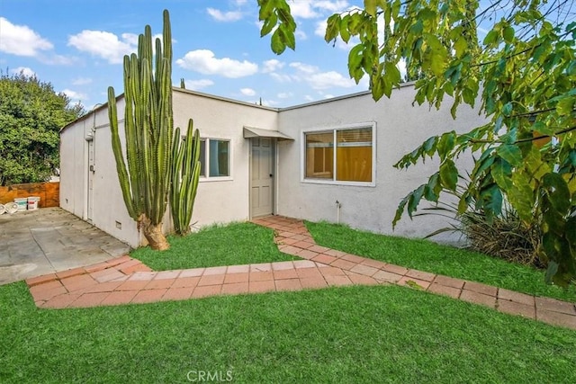 rear view of property featuring a lawn and a patio