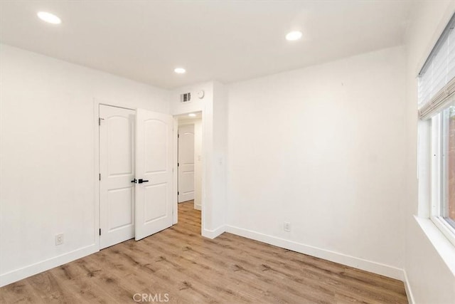 unfurnished bedroom with light hardwood / wood-style flooring and multiple windows