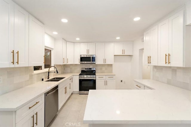 kitchen featuring backsplash, sink, white cabinetry, and appliances with stainless steel finishes