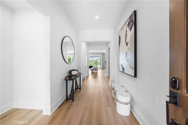 hallway featuring light wood-style floors, baseboards, and recessed lighting