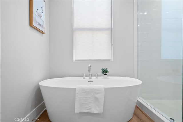 full bathroom with a soaking tub and a tile shower