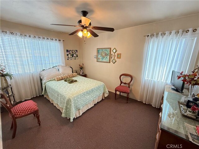 bedroom with ceiling fan and dark carpet