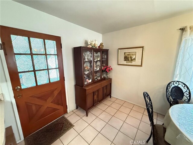 doorway to outside with light tile patterned floors