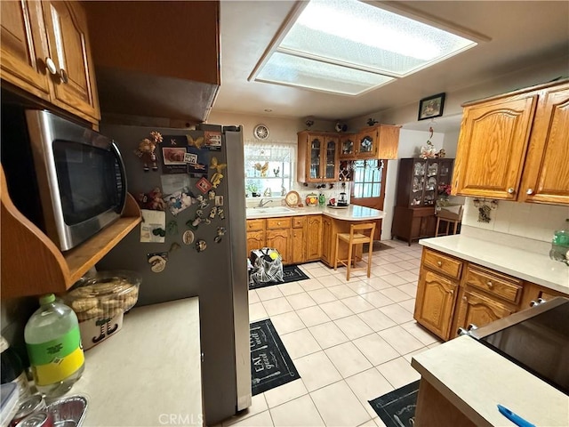 kitchen featuring sink, stainless steel appliances, and light tile patterned flooring