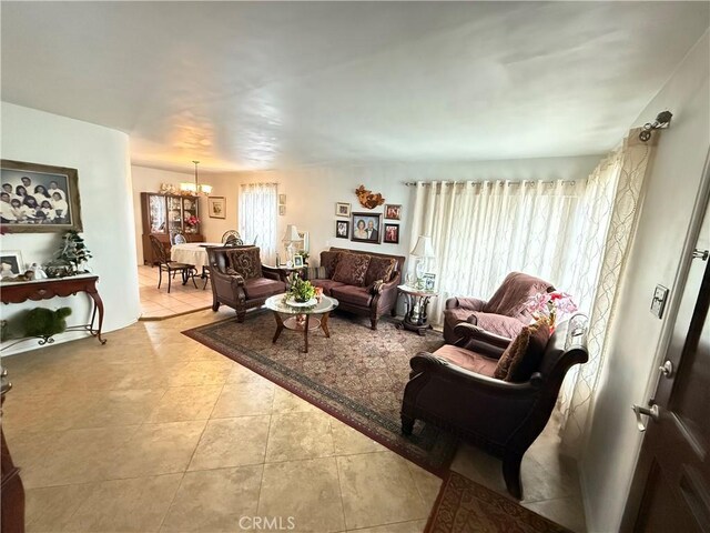 living room with light tile patterned floors and an inviting chandelier