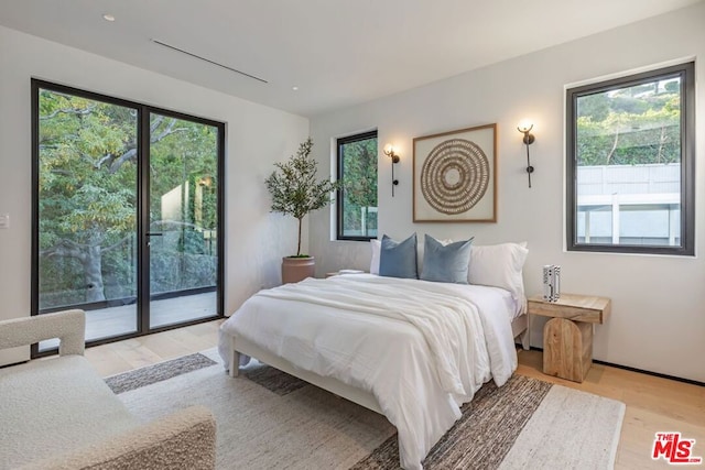 bedroom with access to outside and light hardwood / wood-style flooring