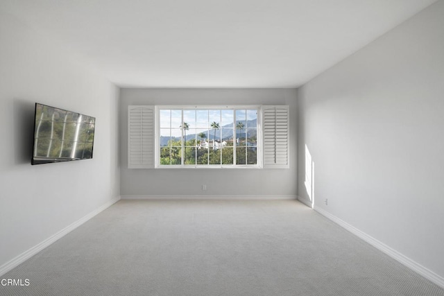 carpeted empty room with baseboards