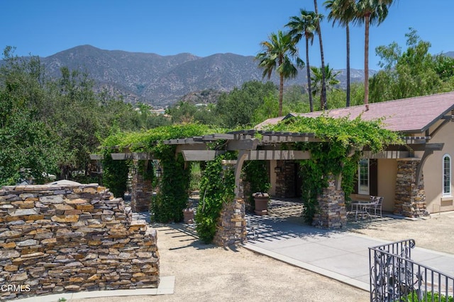 exterior space with a patio area, a mountain view, and a pergola