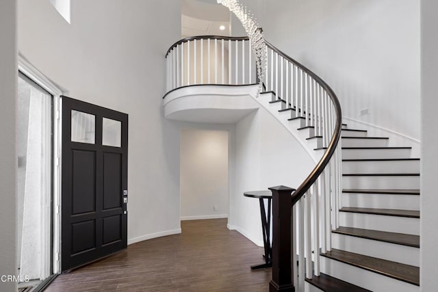 entryway featuring a high ceiling, wood finished floors, visible vents, baseboards, and stairway