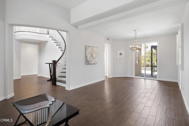 interior space featuring stairway, baseboards, arched walkways, and dark wood-style flooring