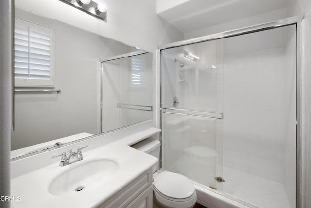 bathroom featuring a stall shower, vanity, and toilet