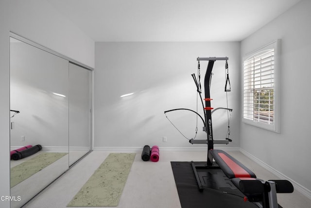 exercise room featuring carpet and baseboards