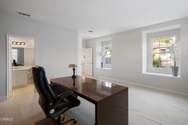 home office with light carpet, baseboards, visible vents, and light tile patterned flooring