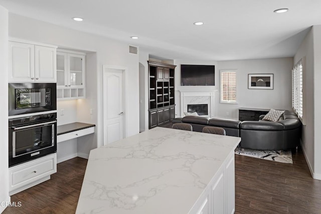 kitchen with black appliances, visible vents, white cabinets, and dark wood-style flooring