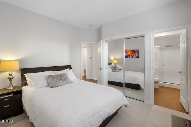 bedroom featuring a closet, baseboards, and ensuite bath