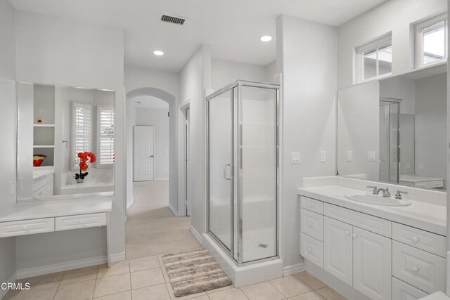 bathroom with a healthy amount of sunlight, a shower stall, visible vents, and vanity