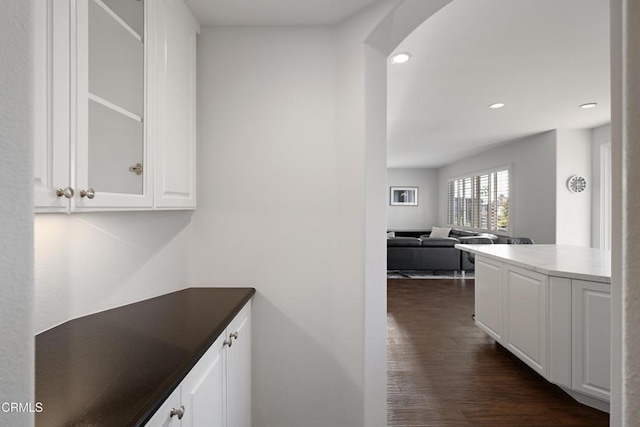 interior space with arched walkways, dark wood-type flooring, and recessed lighting