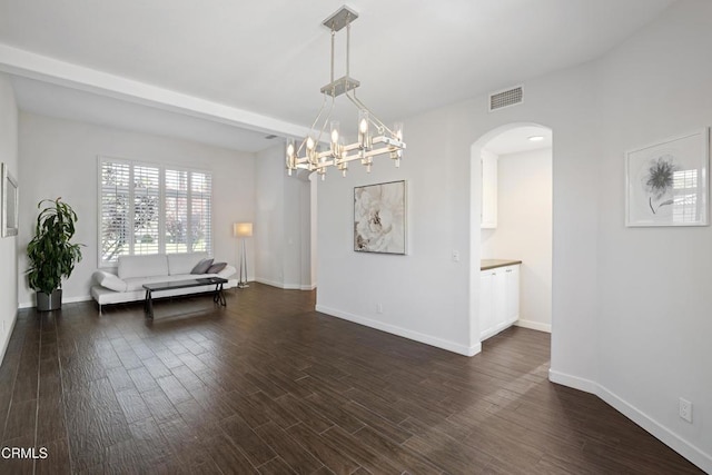 interior space featuring dark wood-style floors, arched walkways, visible vents, and baseboards