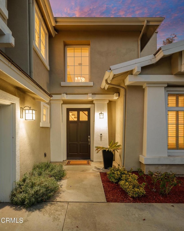 exterior entry at dusk with stucco siding