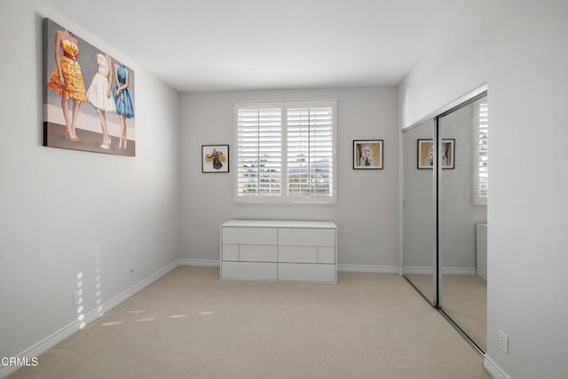 unfurnished bedroom with a closet, carpet, and baseboards