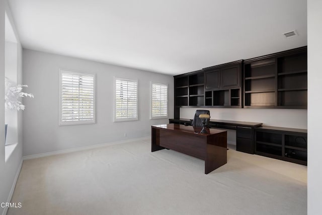 office area featuring visible vents, baseboards, and light colored carpet