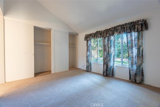 unfurnished bedroom with carpet floors and lofted ceiling