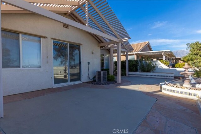 view of patio / terrace with central AC unit and a pergola