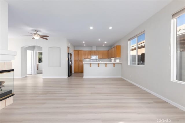 unfurnished living room with ceiling fan and light hardwood / wood-style floors