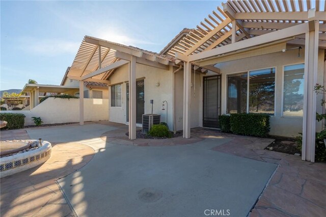 back of property featuring cooling unit, a pergola, and a patio area