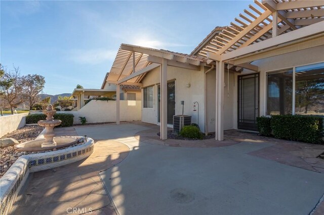 back of property featuring central air condition unit, a patio, and a pergola