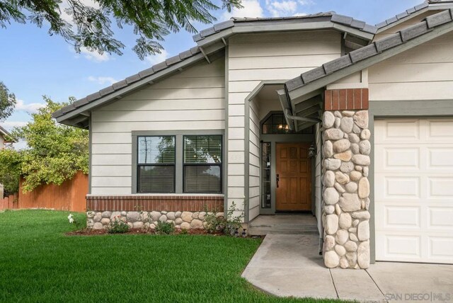 property entrance with a yard and a garage