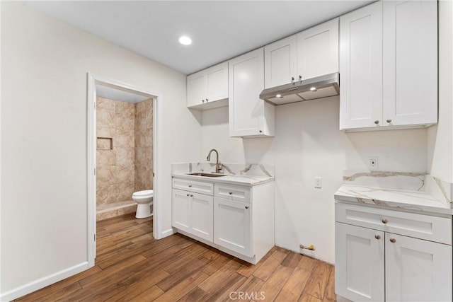 kitchen with white cabinets, sink, and light stone counters