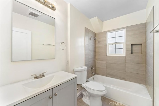 full bathroom featuring tiled shower / bath combo, vanity, and toilet