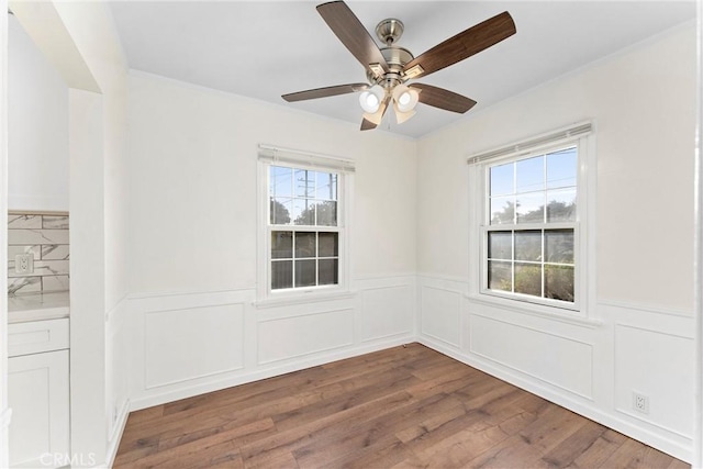 empty room featuring ceiling fan, a wealth of natural light, and hardwood / wood-style flooring