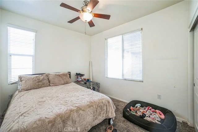 bedroom with multiple windows, a ceiling fan, and carpet flooring