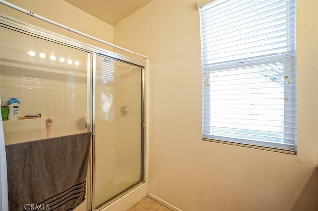 full bath with a shower with door and tile patterned floors