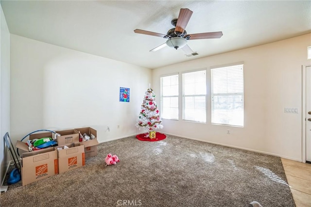 recreation room featuring light colored carpet, visible vents, ceiling fan, and baseboards