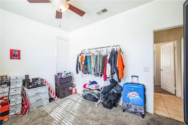 carpeted bedroom with tile patterned flooring, visible vents, and a ceiling fan