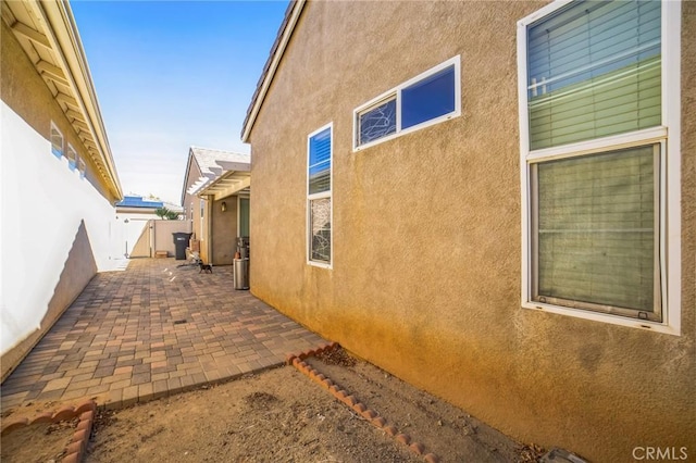 view of home's exterior featuring a patio area, fence, and stucco siding