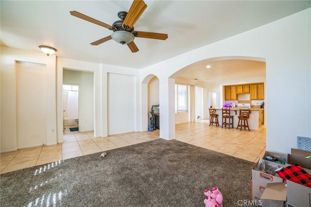 unfurnished living room with ceiling fan and light colored carpet